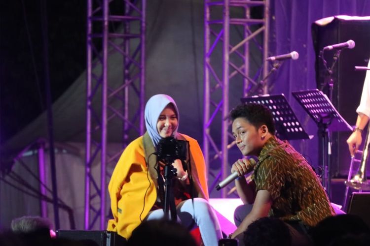 Penyanyi Calvin Jeremy mengajak seorang penonton ke panggung Prambanan Jazz 2019 yang digelar di Kompleks Candi Prambanan, Kabupaten Sleman, Daerah Istimewa Yogyakarta, Jumat (5/7/2019) malam.