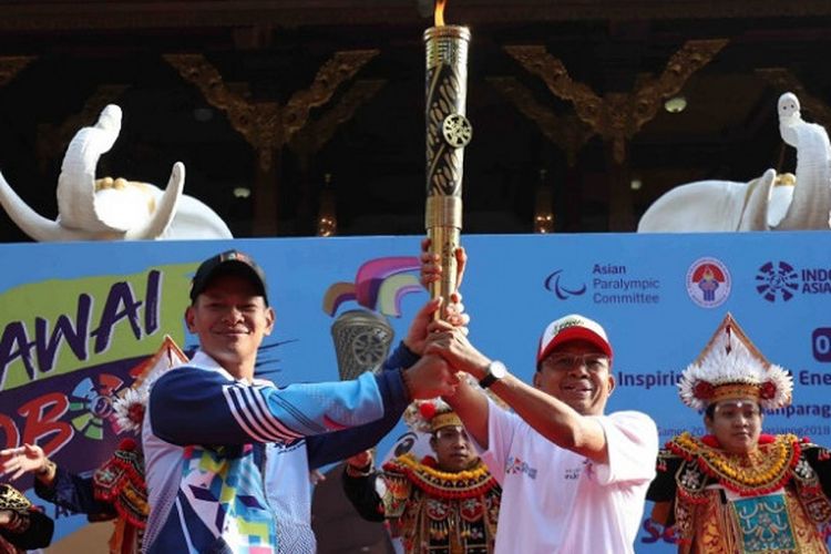 Ketua Umum Inapgoc Raja Sapta Oktohari (kiri) memegang obor yang digunakan pada pawai obor jelang Asian Para Games 2018 di Bali, Minggu (16/9/2018).
