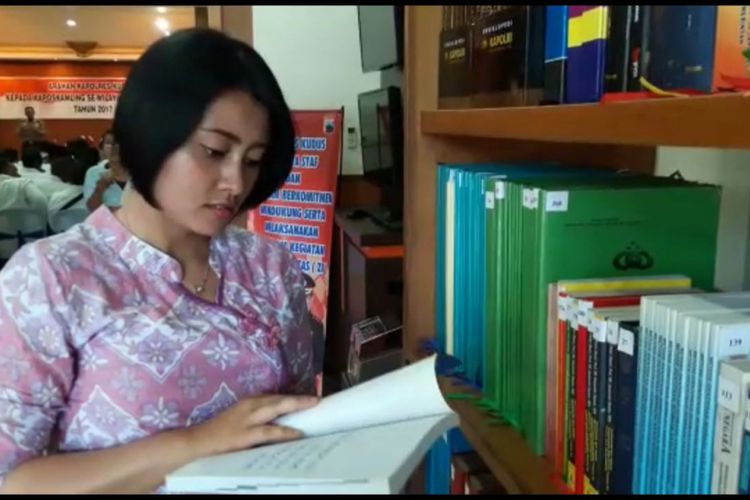 Seorang polwan cantik,  sedang membaca buku di Pojok Baca Polres Kudus,  Kamis (19/10/2017)