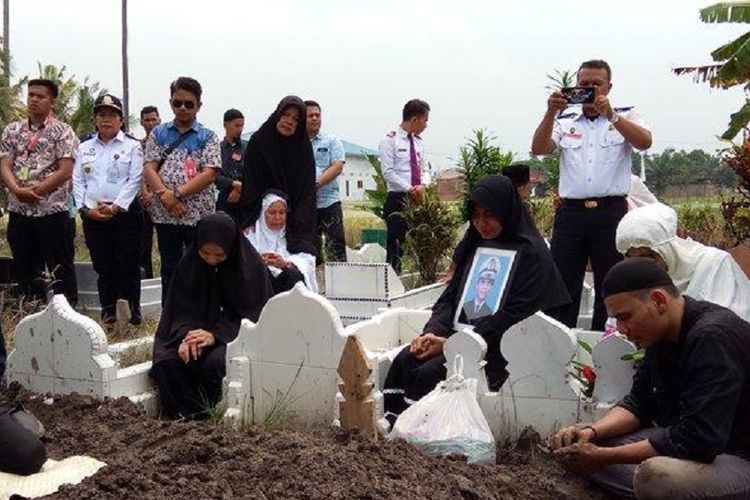 Egin Nasution, anak bungsu Kapten Muas Efendi (paling kanan), korban jatuhnya Lion Air JT 610, di pemakaman, Sabtu (10/11/2018).