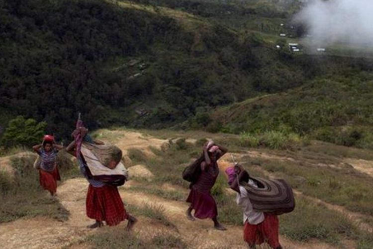 Perempuan menggunakan noken (tas khas Papua) mambawa beban berat melewati bukit terjal di Distrik Kurima, Kabupaten Yahukimo, Papua, Kamis (3/5/2012). Tas khas Papua yang terbuat dari rajutan kulit kayu diusulkan untuk menjadi warisan budaya dunia ke UNESCO. 
