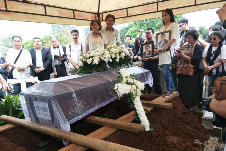 Johan Haris Saruinsong dan Shila Venita beridiri di depan peti mati putranya, Hizkia Jorry Saruinsong di Tempat Pemakaman Umum Menteng Pulo, Jakarta Selatan siang tadi, Senin (5/11/2018).