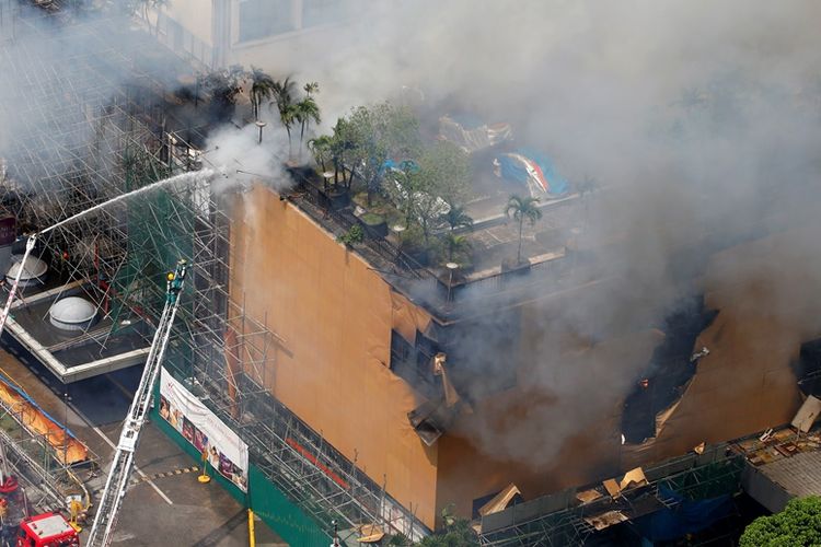 Petugas pemadam kebakaran berusaha menjinakkan api di Hotel Waterfront Manila Pavilion di Manila, Filipina, Minggu (18/3/2018).