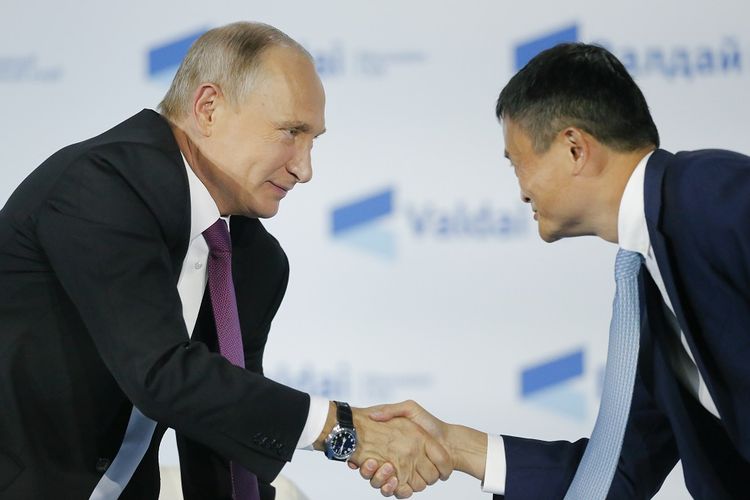 Presiden Rusia Vladimir Putin (kiri) berjabat tangan dengan pendiri raksasa e-commerce Alibaba Jack Ma di Sochi pada 19 Oktober 2017.