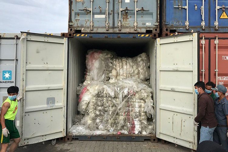 Foto yang dirilis Kementerian Lingkungan Hidup Kamboja, Selasa (16/7/2019), memperlihatkan petugas membuka kontainer berisi sampah plastik di pelabuhan Sihanoukville, Kamboja, yang berasal dari luar negeri.