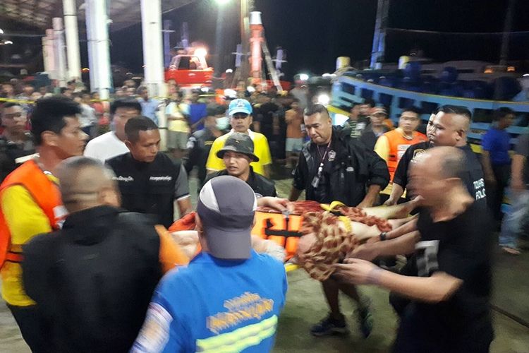 Petugas penyelamat dan paramedis menangani salah satu penumpang kapal wisata yang terbalik di laut lepas sesaat setelah tiba di pelabuhan di Phuket, Kamis (5/7/2018).