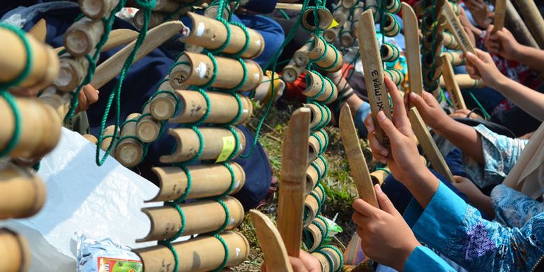 Sejumlah pelajar memainkan alat musik tradisional Calung renteng pada acara Preanger Tourism Fair 2018 di Karangresik, Kota Tasikmalaya, Jawa Barat, Minggu (14/10/2018). Pertunjukan yang dikemas lewat kolaborasi antara calung renteng, angklung, perkusi dan alat musik modern itu dimainkan oleh 1.093 pelajar dari 15 sekolah bertujuan untuk melestarikan calung renteng agar lebih dikenal oleh generasi muda.  