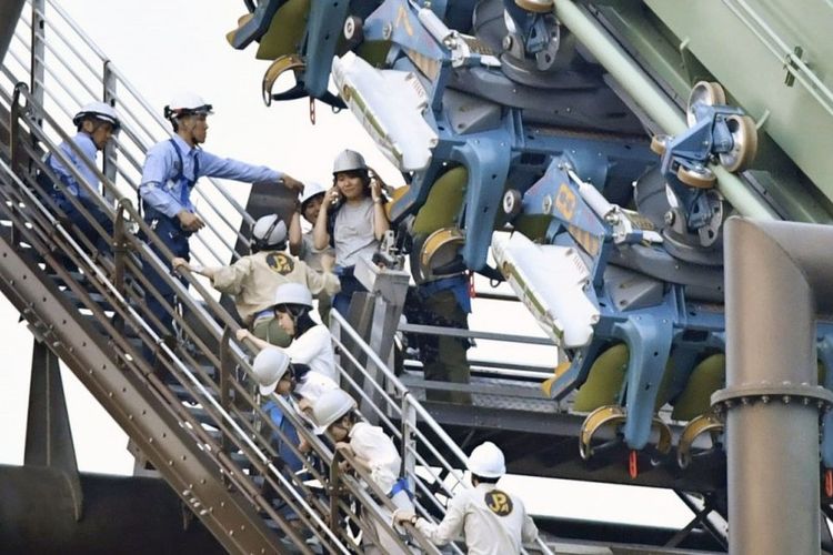Petugas membantu penumpang wahana permainan yang macet di Taman Hiburan Osaka, Jepang, Selasa (1/5/2018).