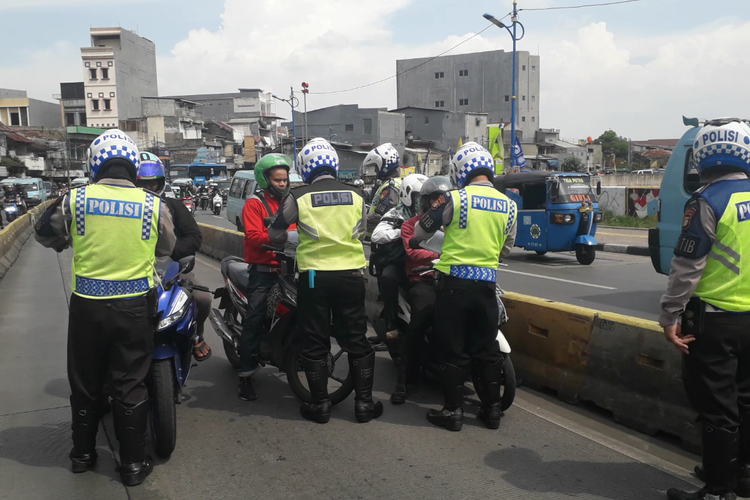 Sejumlah pengendara sepeda motor ditilang polisi karena menerobis jalur transjakarta di Jalan Jatinegara Barat, Rabu (20/3/2019).