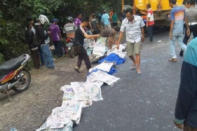 Sejumlah korban tewas tampak ditutupi koran sesaat setelah kecelakaan truk bertabrakan dengan bus Rosalia Indah, Senin (16/9/2019).