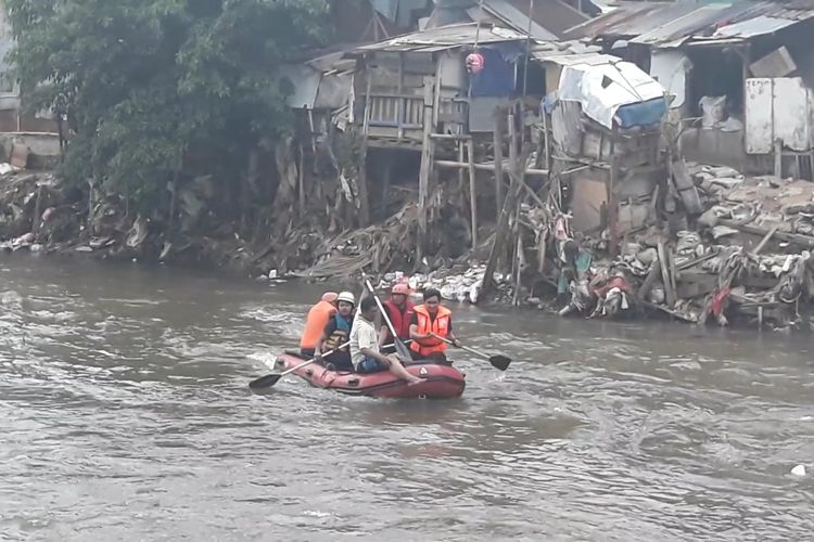 Petugas menyisir Sungai Ciliwung untuk mencari bocah Fikri yang hanyut di sungai tersebut, Selasa (23/4/2019).