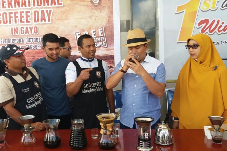 Ketua Gayo Cupper Team (GCT), Mahdi Usati, saat memberikan kopi racikannya kepada Bupati Bener Meriah dalam International Coffee Day In Gayo, Minggu (1/10/2017), di Bandara Rembele, Bener Meriah, Aceh.