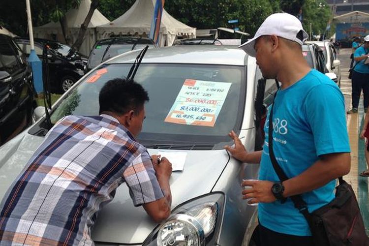 Sales mobil88 sedang memproses calon pembeli yang datang di acara Weekend Surprise Mobil88 di Senayan, Minggu (7/6/2015)