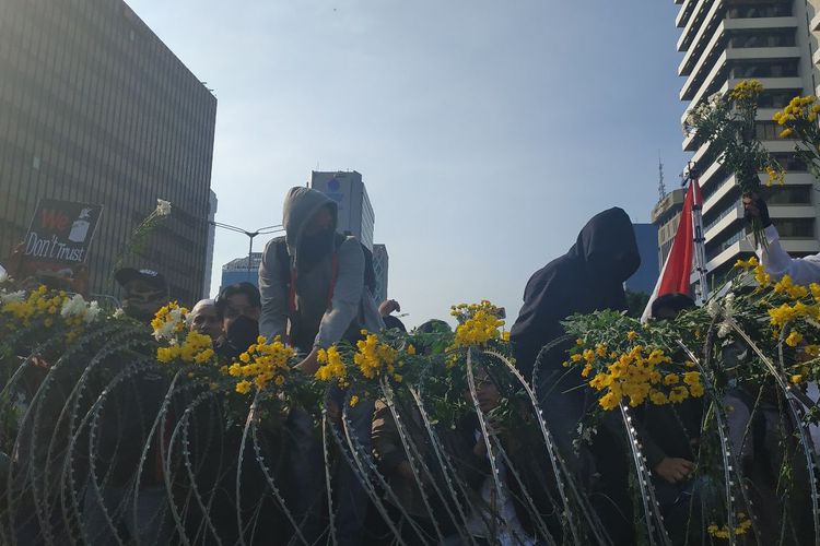 Sejumlah bunga diletakkan di pagar kawat berduri yang menghalau massa aksi di depan Bawaslu sebagai simbol duka cita atas insiden yang terjadi di Tanah Abang pada Rabu (22/5/2019).