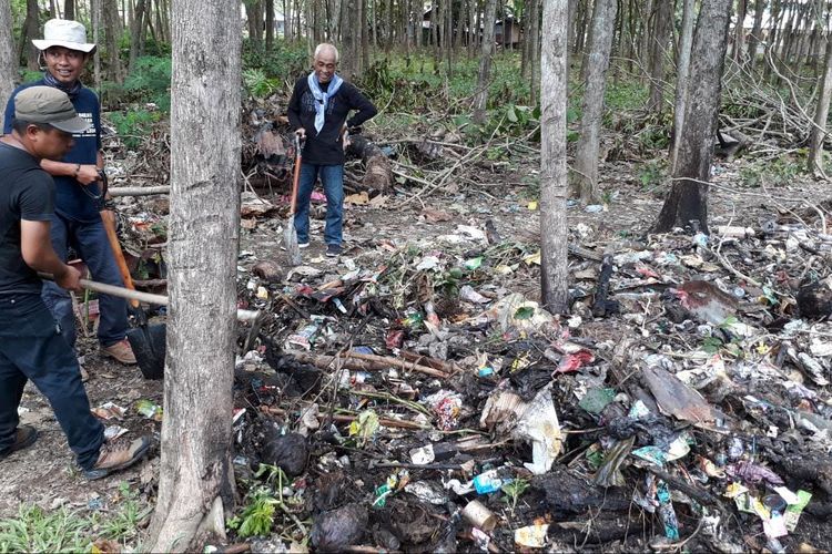 Para peneliti memindahkan sampah yang menumpuk di reruntuhan Benteng Maas di Kabupaten Gorontalo Utara
