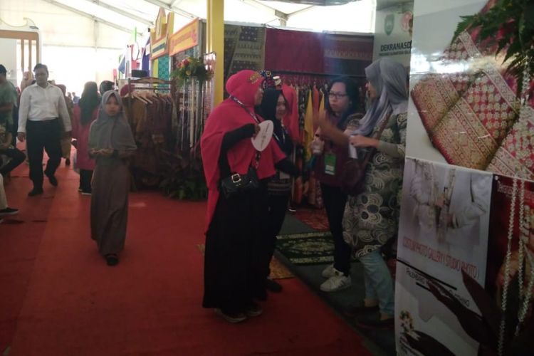 Para pengunjung di Sriwjaya Expo terlihat membawa kipas akibat padamnya listrik dilokasi pameran hingga membuat kondisi didalam stand menjadi panas, Kamis (16/8/2018).