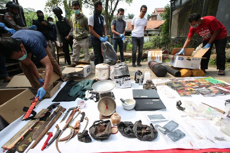 Polisi menunjukkan barang bukti di lokasi penangkapan terduga teroris di Kelurahan Nanggewer, Kecamatan Cibinong, Kabupaten Bogor, Jawa Barat, Sabtu (18/5/2019). Di lokasi ini polisi menangkap terduga teroris E alias AR (51).