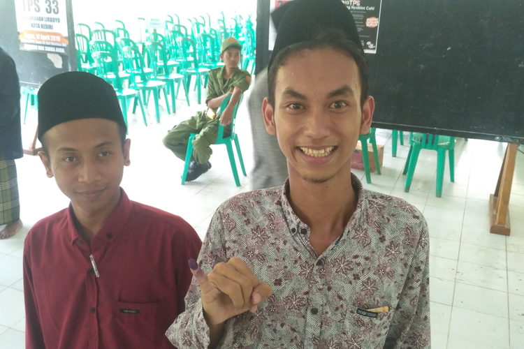 Salah seorang santri pesantren Lirboyo Kota Kediri, Jawa Timur menunjukkan tinta ungu di jarinya tanda usai menyalurkan suara pada pemilu, Rabu (17/4/2019).