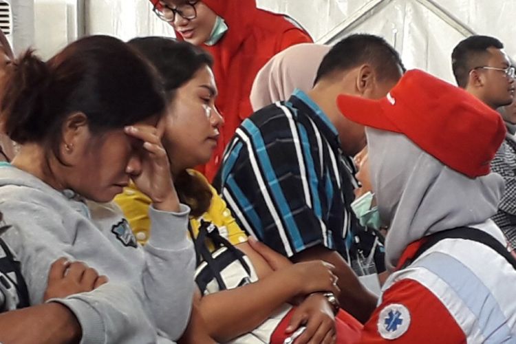 Seorang petugas PMI tengah menenangkan anggota keluarga salah seorang penumpang Lion Air JT 610 yang menangis di KRI Banjarmasin, Selasa (6/11/2018).