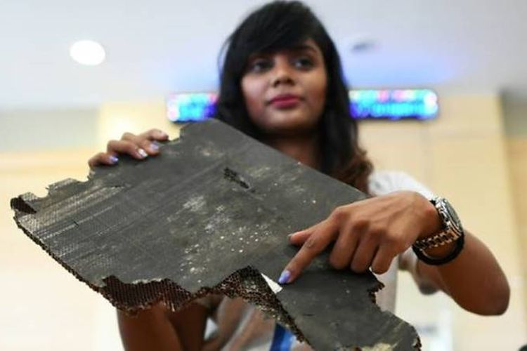 Grace Nathan, salah satu kerabat penumpang penerbangan MH370, menunjukkan serpihan puing yang diyakini milik pesawat yang hilang.