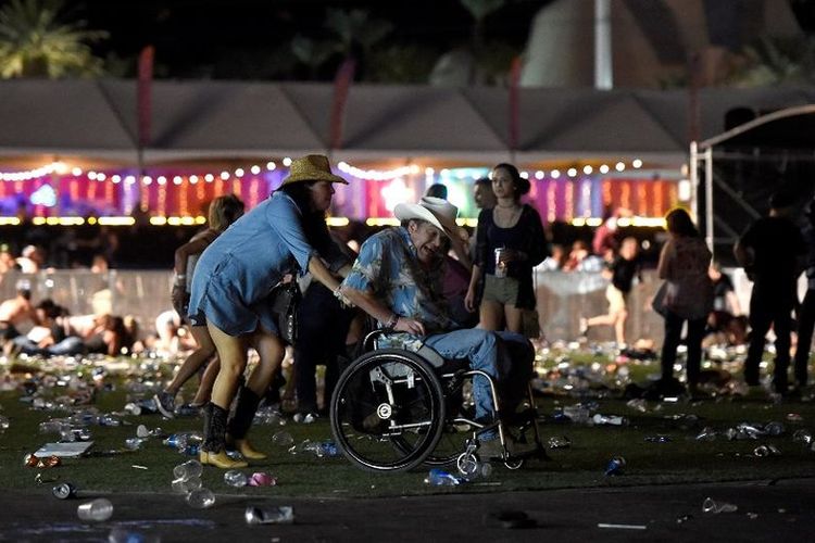 Seorang pria dengan kursi roda dibawa keluar dari festival musik country Route 91 Harvest setelah terjadi terdengar suara tembakan di Las Vegas, Nevada, Minggu (1/10/2017). Pelaku penembakan diduga berada di sekitar Mandalay Bay Resort and Casino.