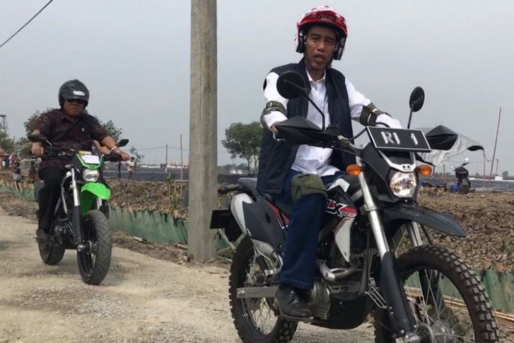 Presiden Joko Widodo mengendarai motor trail Kawasaki KLX 150 meninjau lokasi tambak udang dan ikan bandeng sebagai bagian dari program perhutanan sosial di Kecamatan Muara Gembong, Bekasi, Rabu (1/11/2017). Terlihat ada Menteri Pekerjaan Umum dan Perumahan Rakyat Basuki Hadimuljono mendampingi di belakangnya.