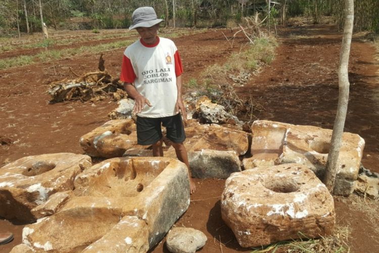 Pemilik lahan Harjo Winoto (55) saat menunjukkan batuan yang diduga dari zaman Megalitik, Selasa (8/8/2018).