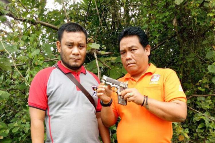 Polisi memperlihatkan pistol rakitan jenis FN sesaat setelah diterima dari warga di Desa Beurandang, Kecamatan Cot Girek, Kabupaten Aceh Utara, Jumat (17/11/2017).