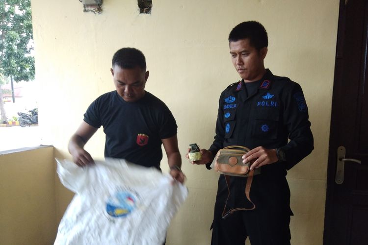 Kasie Ops Satbrimob Polda NTT, AKP Bayu Purdantono, bersama seorang anggota Gegana Brimob, memperlihatkan granat dan barang-barang terkait lainnya di Kupang, NTT, Sabtu (30/3/2019)