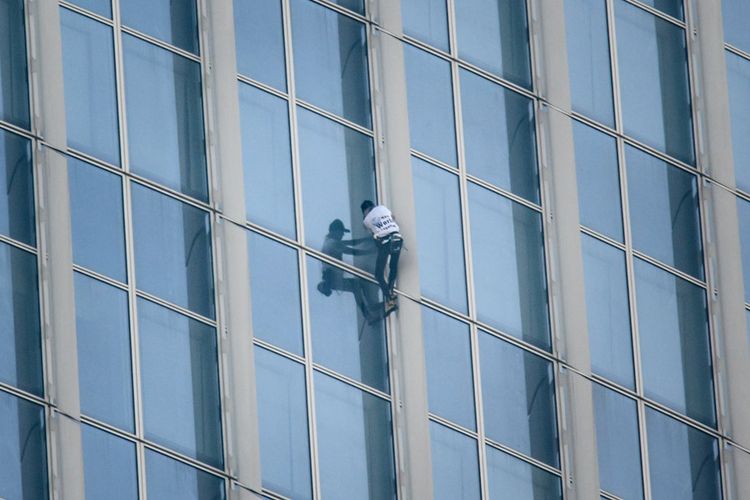 Pemanjat bebas asal Perancis, Alain Robert saat memanjat gedung bertingkat Lotte World Tower di Seoul, Rabu (6/6/2018).