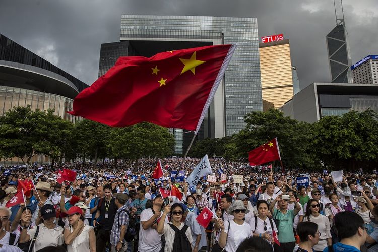 Puluhan ribu orang yang mengaku sebagai massa pro-pemerintah menggelar aksi mendukung aparat kepolisian Hong Kong di luar parlemen, Minggu (30/6/2019).