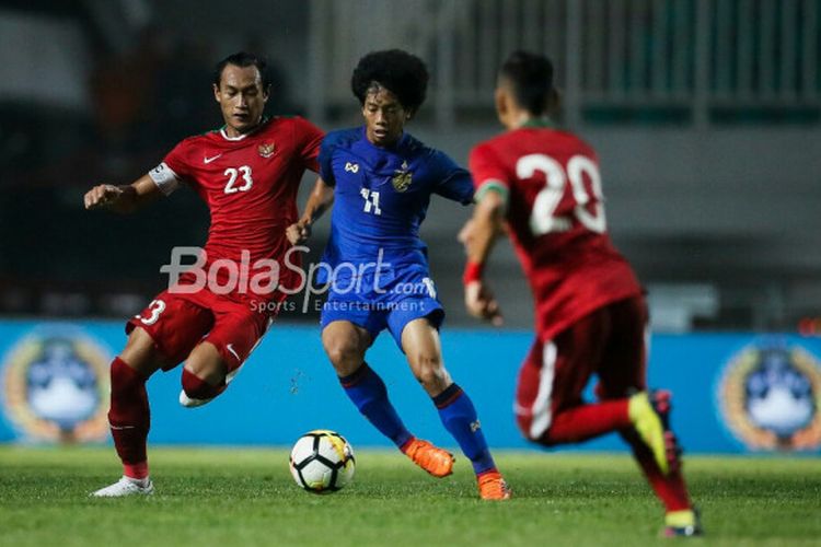 Bek timnas U-23 Indonesia,, Hansamu Yama Pranata, mengawal pemain timnas U-23 Thailand, Tanasith Siripala, di Stadion Pakansari, Kabupaten Bogor, Minggu (3/6/2018).
