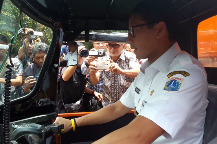 Wakil Gubernur DKI Jakarta Sandiaga Uno mengendarai alat angkut sampah motor roda tiga di Kantor Wali Kota Jakarta Utara, Rabu (14/3/2018).