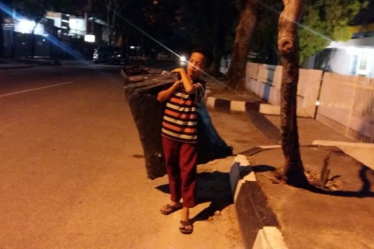 Ucok melintas di Jalan Sumatera, Pekanbaru, menuju pulang ke rumah membawa barang bekas, Senin (23/7/2018).