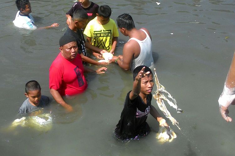 Warga mencuci jeroan binatang kurban, sapi maupun kambing, di Sungai Serang, Kulon Progo. Tidak hanya anak muda dan orang tua, banyak sekali anak-anak terlibat membersihan jeroan di sungai ini.