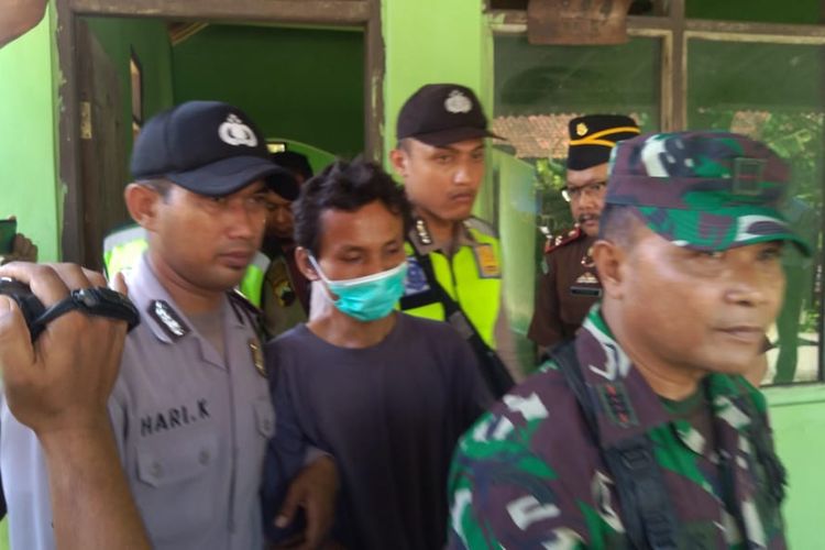 Anal Rojikun (memakai masker), tersangka perusakan masjid dan TPQ di Desa Buniayu,Kecamatan Tambak, Kabupaten Banyumas, Jateng, diminta menunjulkan lokasi yang menjadi sasaran aksinya, Jumat (22/3/2019). 