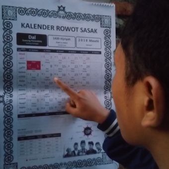 Seorang warga di Mataram menunjukkan kalender Riwot Sasak yang merupakan terjemahan dari papan Warige atau penanggalan tradisional suku Sasak.