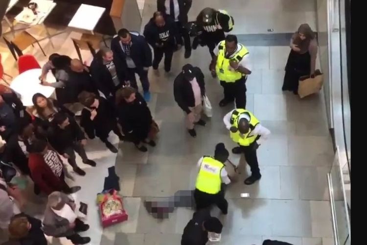 Petugas memeriksa korban perempuan yang tertimpa seorang pria yang jatuh di pusat perbelanjaan di Westfield, Stratford, London, Rabu (17/10/2018).