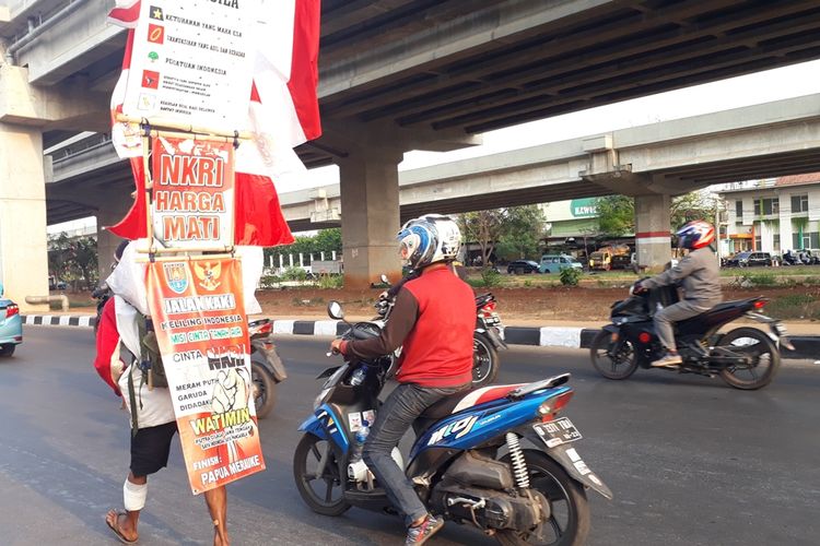 Watimin (36) pria asal Cilacap, Jawa Tengah yang melakukan aksi jalan kaki keliling Indonesia sedang berjalan di Jalan Irigasi Kalimalang, Duren Sawit, Jakarta Timur, Jumat (6/9/2019).
