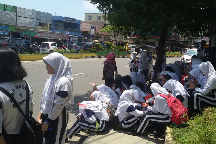 Siswa di Pangkal Pinang berkelompok di pinggir jalan menyambut kedatangan rombongan kepala negara, Kamis (14/3/2019).