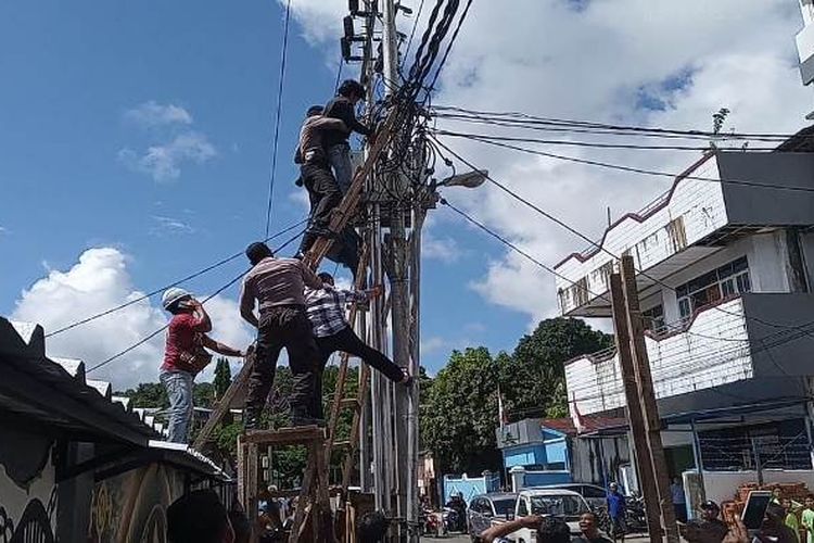 Sejumlah petugas PLN dan aparat kepolisian berusaha menurunkan Mualif, petugas pemasang jaringan listrik yang kesetrum di sebuah tiang listrik di Jalan dr Latumeten Ambon, Juamt (10/5/2019)