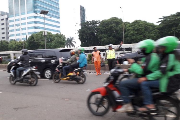 Petugas PPSU membersihkan sampah bekas aksi demo di depan gedunh DPR RI, Jalan Gatot Subroto, Jakarta Pusat pada Senin (23/4/2018).