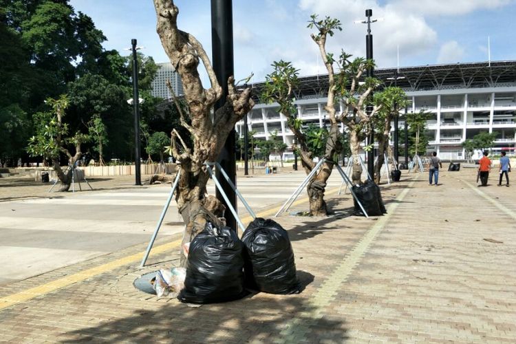 Kantong-kantong plastik berisi sampah yang dibersihkan petugas di taman sekitar Stadion Utama Gelora Bung Karno (SUGBK), Senayan, Jakarta Pusat, dua hari pasca-final Piala Presiden, Senin (19/2/2018).