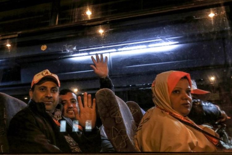 Warga Palestina di Jalur Gaza melambai ke kerabat mereka saat berangkat dengan menggunakan bus menuju Mesir dari perbatasan Rafah pada Minggu (3/3/2019). (AFP/SAID KHATIB)