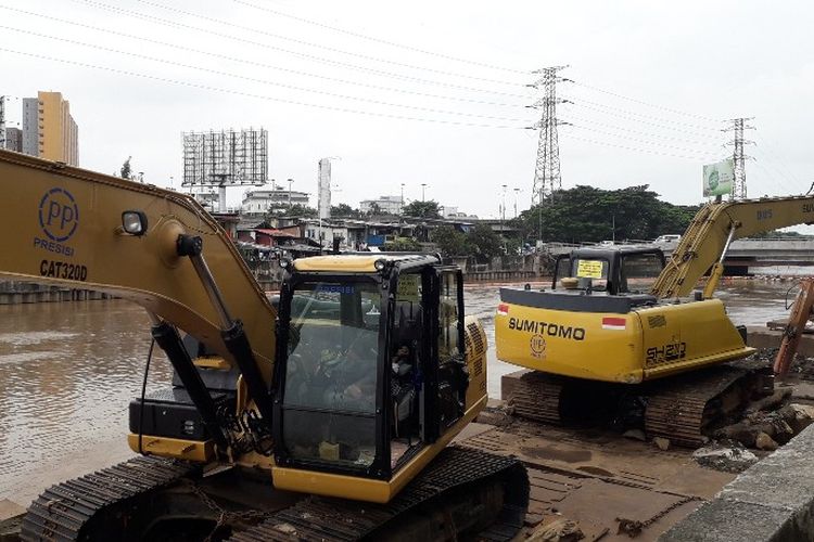 Kondisi kali Kanal Banjir Barat depan mal Season City, Jembatan Besi, Jakarta Barat. Akibat arus deras para pekerja eskavator amfibi pengangkut sampah tak bisa bekerja dan memilih beristirahat. 