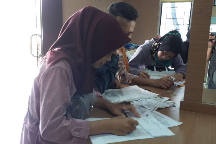 Beberapa warga sedang mengisi blanko pembuatan e-KTP di kantor Disdukcapil Palembang