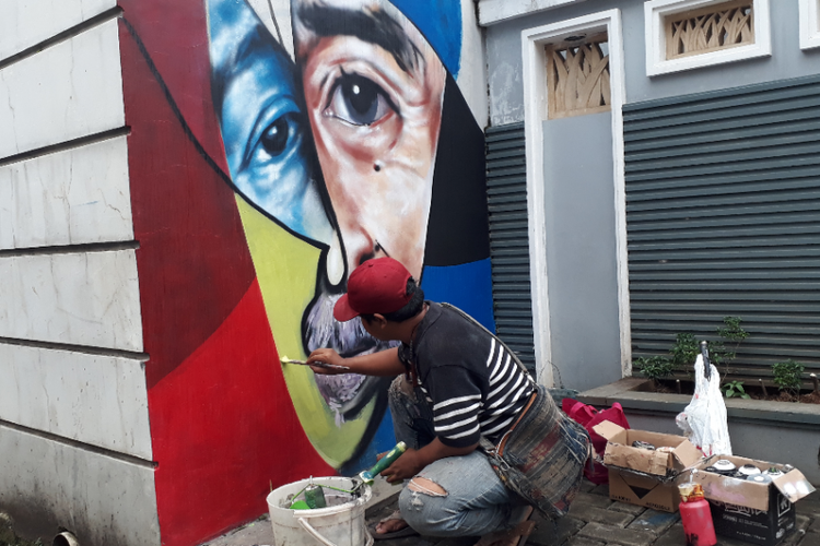Saipul Bahri tampak menggambar mural perpaduan wajah bertema Mural Islami di Gang Abdul Jabar, Kelurahan Jagakarsa, Jakarta Selatan, Rabu (23/5/2018) sore.