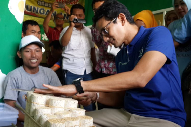 Calon wakil presiden nomor urut 02 Sandiaga Salahudin Uno saat mengiris tempe dengan ukuran yang tipis di Sentra Industri Keripik Tempe Sanan, Kota Malang, Jumat (23/11/2018)