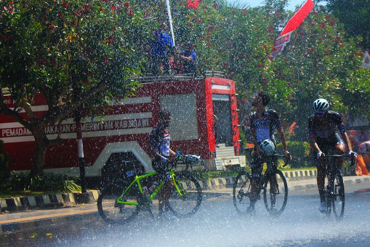 Sejumlah peserta balap sepeda internasional  Bank BRI Tour D?Indonesia 2019 mendinginkan diri usai menyentuh garis finish di Kabupaten Ngawi Jawa Timur. Pesepeda dari tim Olivers Real Food Racing Australia, Lyons 