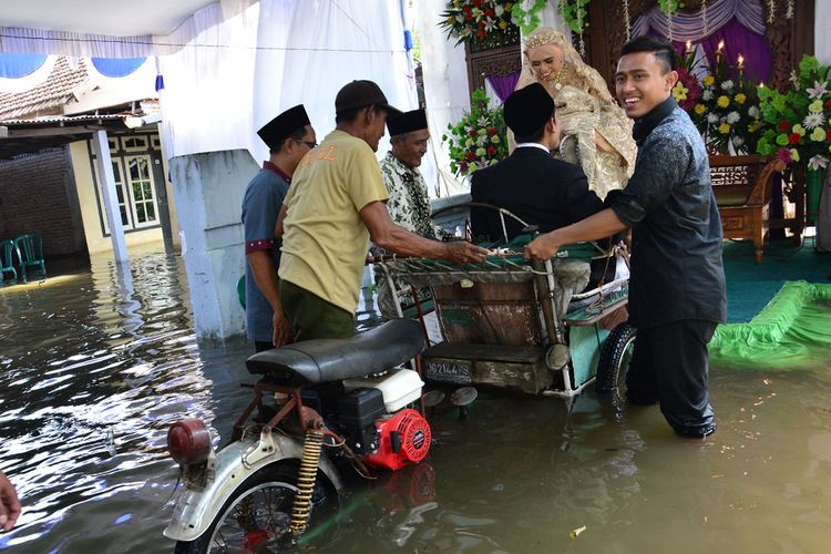 Pasangan Abdul Lathif Anshori dan Elok Faiz Fatma Elfahmi, melangsungkan resepsi pernikahan di tengah kepungan banjir, Rabu (1/5/2019). 